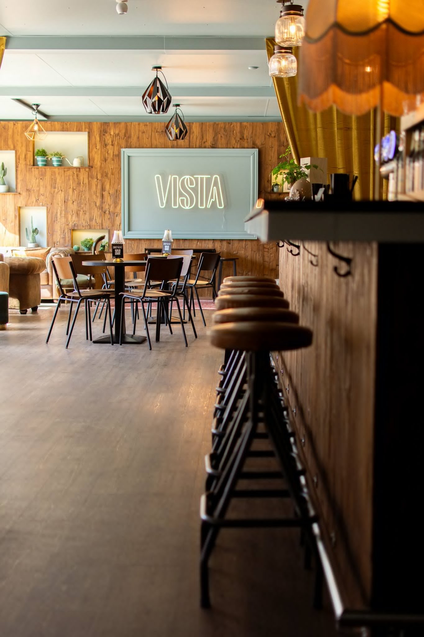 Blick in den renovierten Innenraum der Vista Bar mit Bartresen, Hockern und Holzverkleidung.