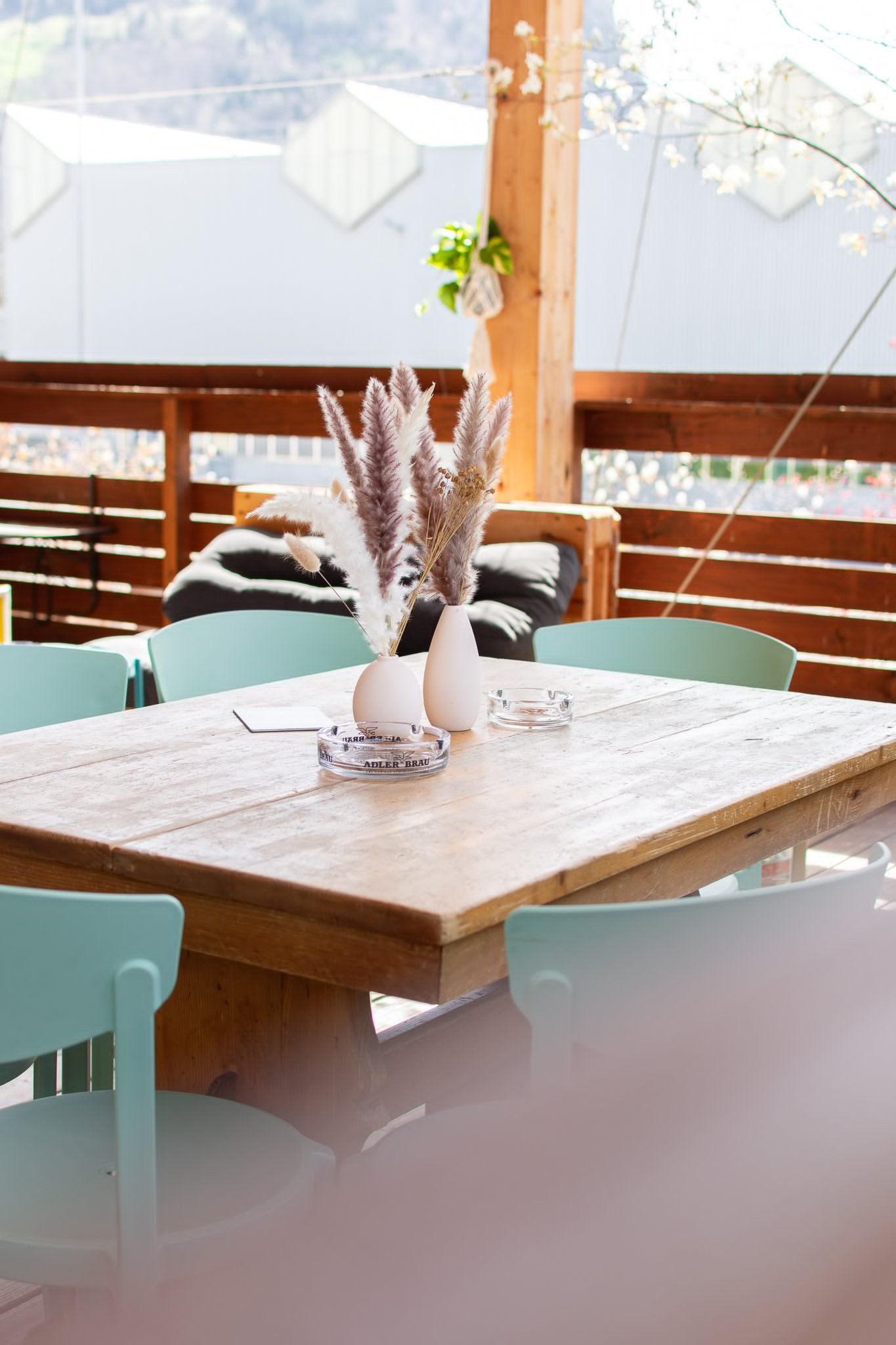 Lange gedeckte Tafel mit Stühlen auf der Dachterrasse der Vista Bar, dahinter die Umgebung von Näfels.